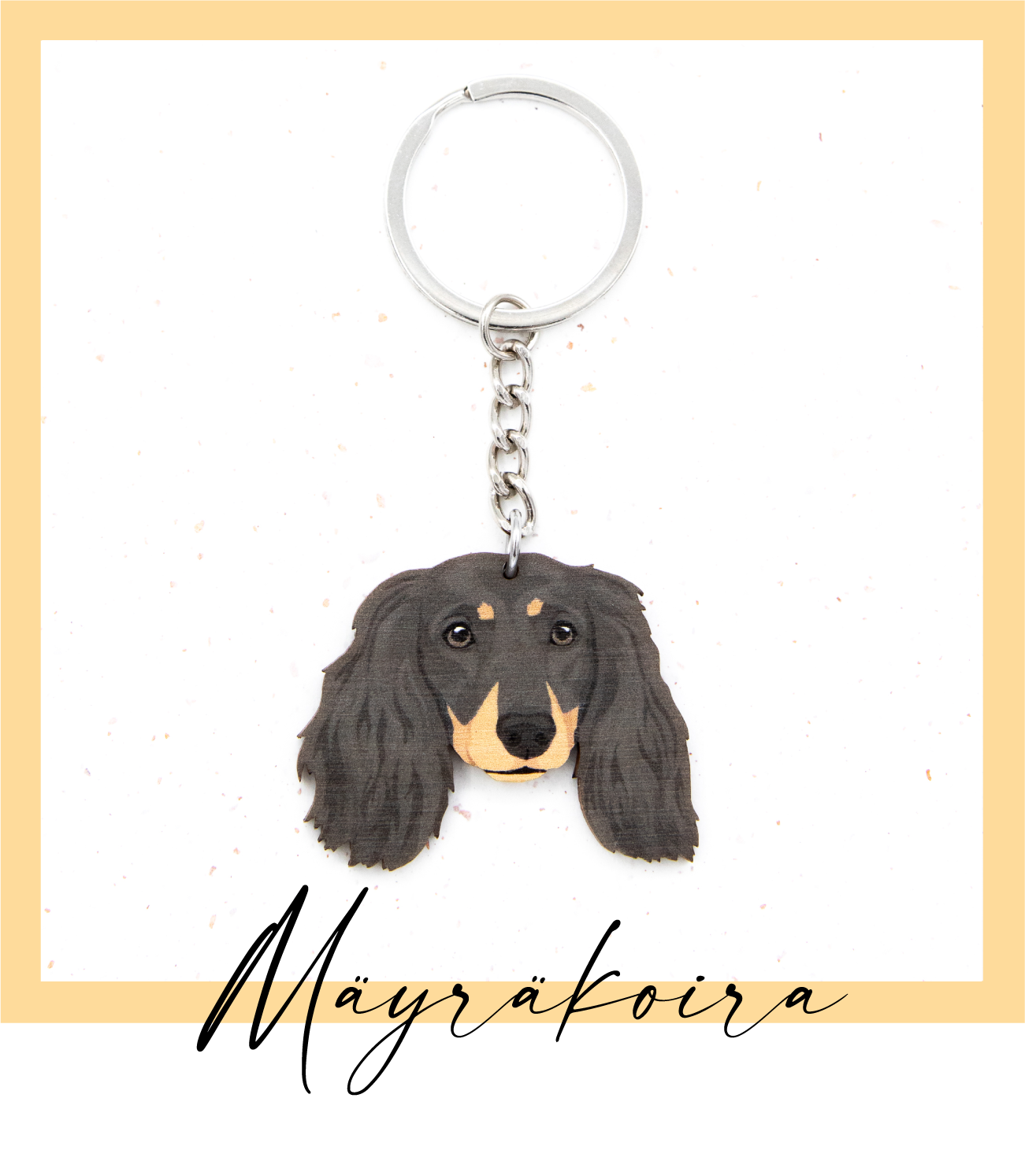 Suomalaisesta koivuvanerista ja teräksestä valmistettu musta punaisin merkein pitkäkarvainen mäyräkoira avaimenperä